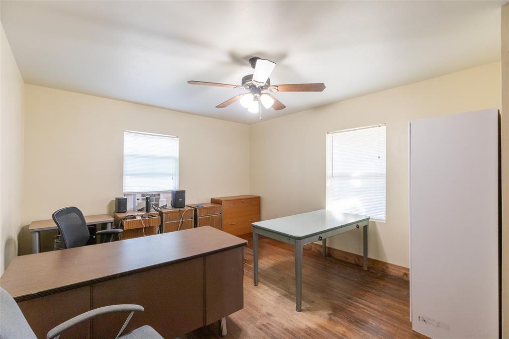 640 Ground Street Moran, TX 76464 - Photo 25 of 35 Spacious room featuring wood-finish flooring, two windows, and a ceiling fan with integrated lighting