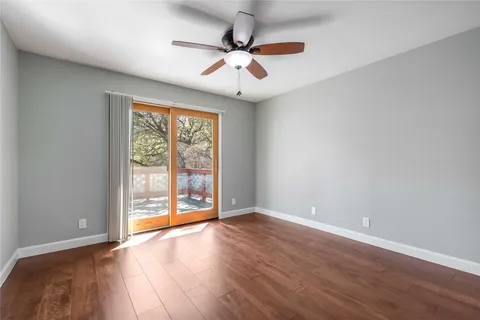 an empty room with wooden floor a ceiling fan and closet