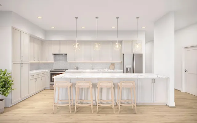 a kitchen with stainless steel appliances kitchen island a table chairs sink and cabinets