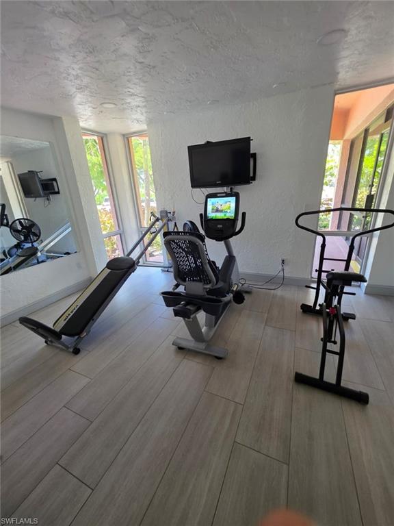 160 Turtle Lake Court, Unit 209 Naples, FL 34105 - Photo 19 of 26 a room with gym equipment and windows