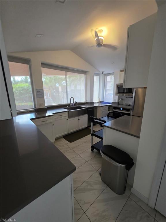 160 Turtle Lake Court, Unit 209 Naples, FL 34105 - Photo 21 of 26 a kitchen with a sink stainless steel appliances a window and dining table