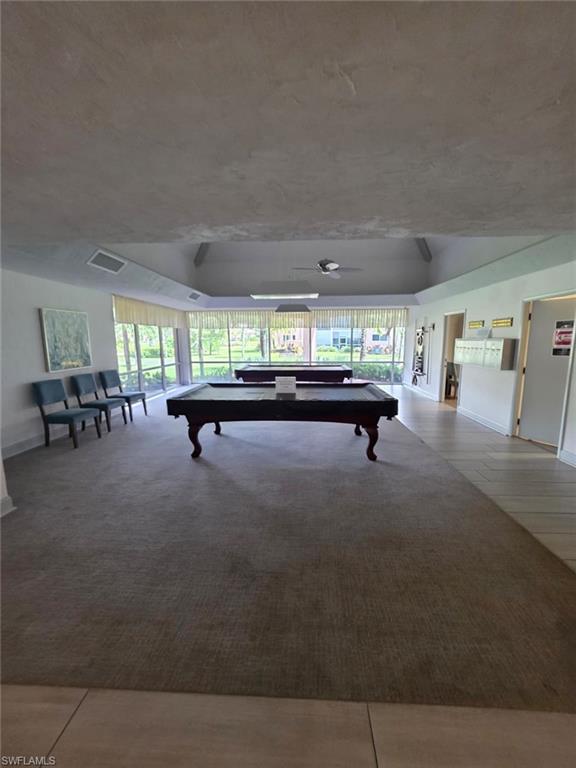 160 Turtle Lake Court, Unit 209 Naples, FL 34105 - Photo 23 of 26 a living room with furniture and a chandelier