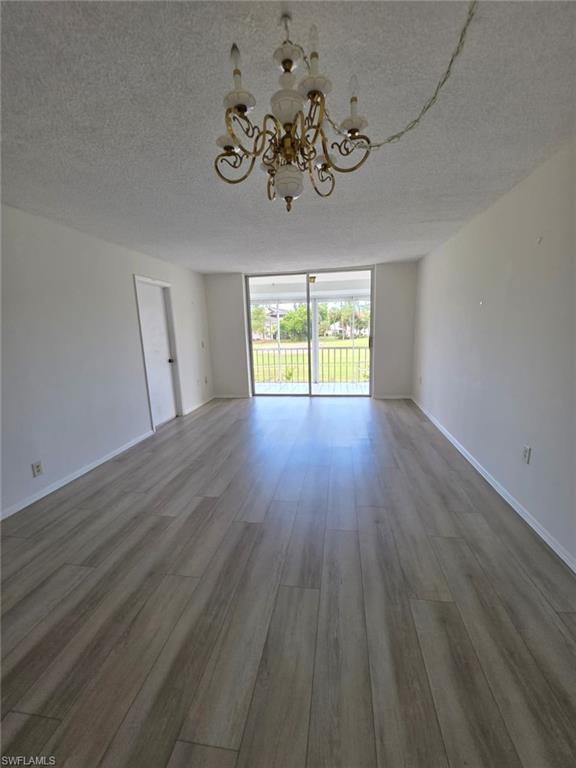 160 Turtle Lake Court, Unit 209 Naples, FL 34105 - Photo 6 of 26 a view of an empty room with wooden floor and a window