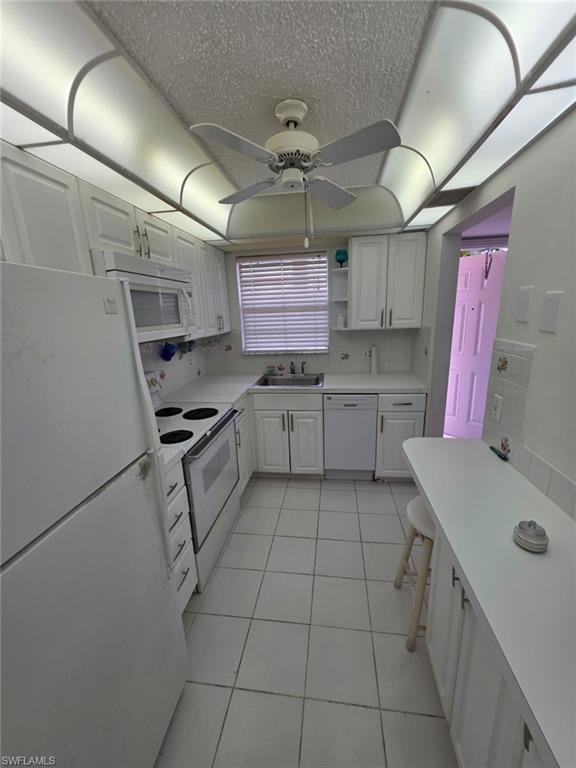 160 Turtle Lake Court, Unit 209 Naples, FL 34105 - Photo 7 of 26 a kitchen with a sink a stove top oven and cabinets