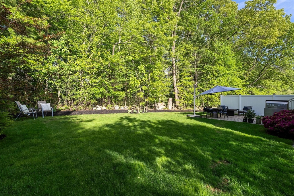 2 Hummingbird Way, Unit 1 Methuen, MA 01844 - Photo 38 of 42 a view of a backyard with table and chairs and a large tree