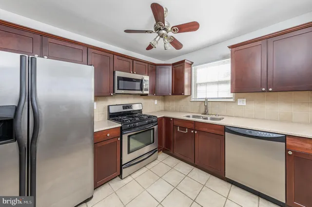 a kitchen with stainless steel appliances granite countertop a stove a sink dishwasher a refrigerator and a microwave oven with cabinets