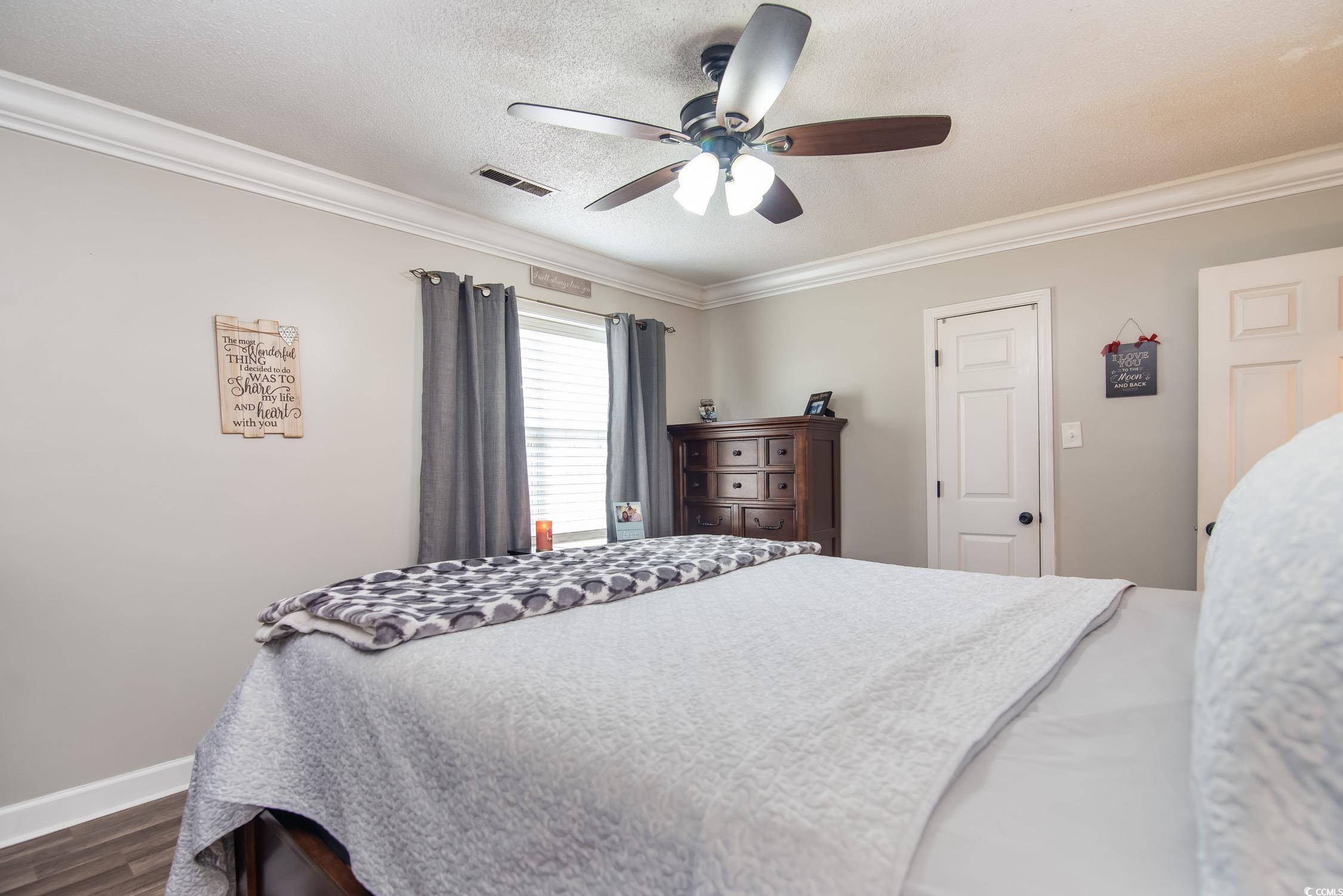 2510 Redwood Street Georgetown, SC 29440 - Photo 14 of 27 Bedroom featuring crown molding, dark wood-style flooring, and a ceiling fan