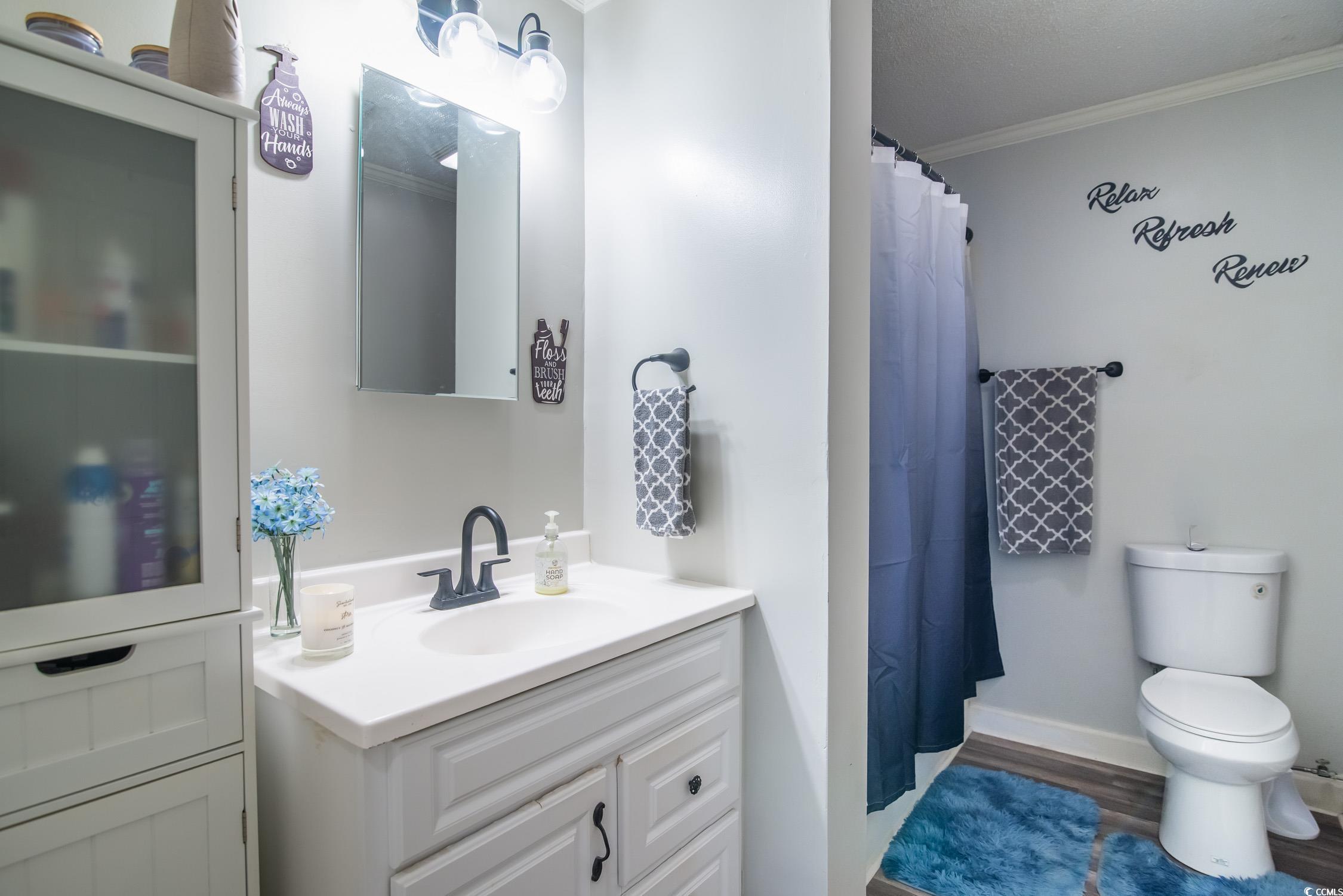 2510 Redwood Street Georgetown, SC 29440 - Photo 15 of 27 Bedroom with crown molding, dark wood-style floors, baseboards, and a ceiling fan