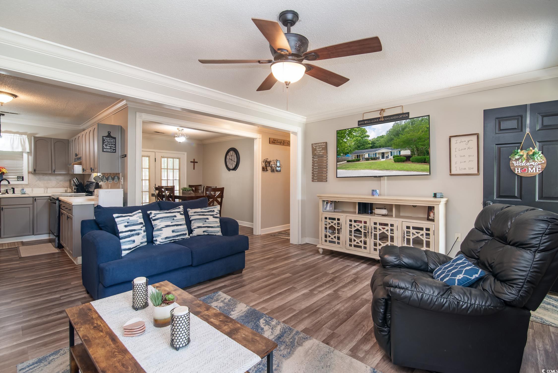 2510 Redwood Street Georgetown, SC 29440 - Photo 6 of 27 Living room with crown molding, ceiling fan, wood finished floors, baseboards, and a textured ceiling