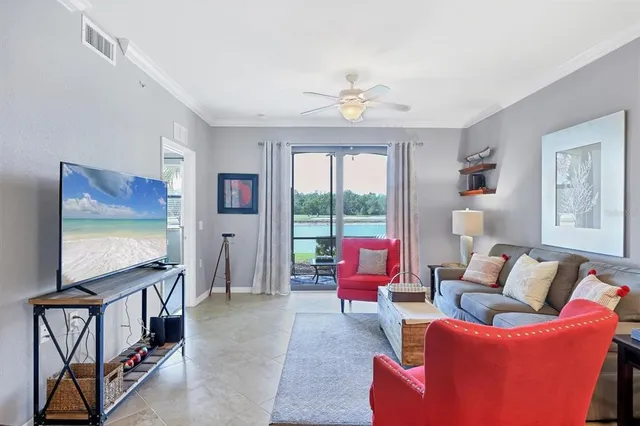 a view of living room kitchen with stainless steel appliances cabinets