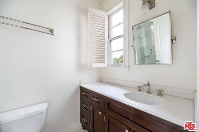 a bathroom with a sink a toilet and a window