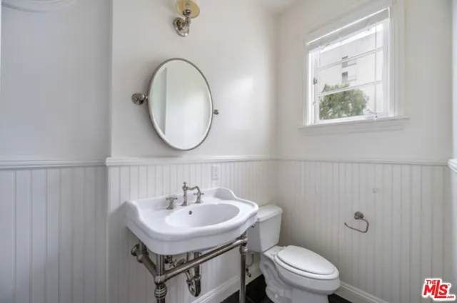 a bathroom with a sink a toilet and a mirror