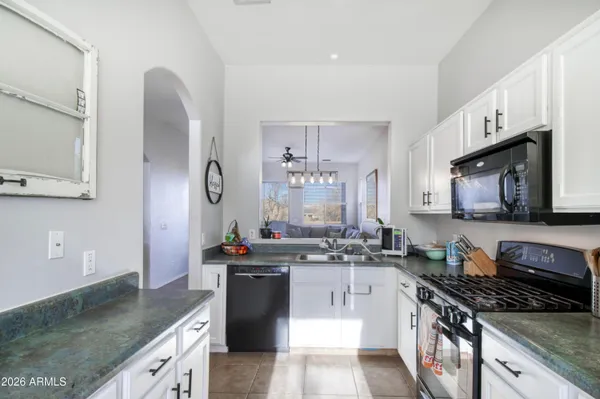 a kitchen with stainless steel appliances granite countertop a sink stove and cabinets