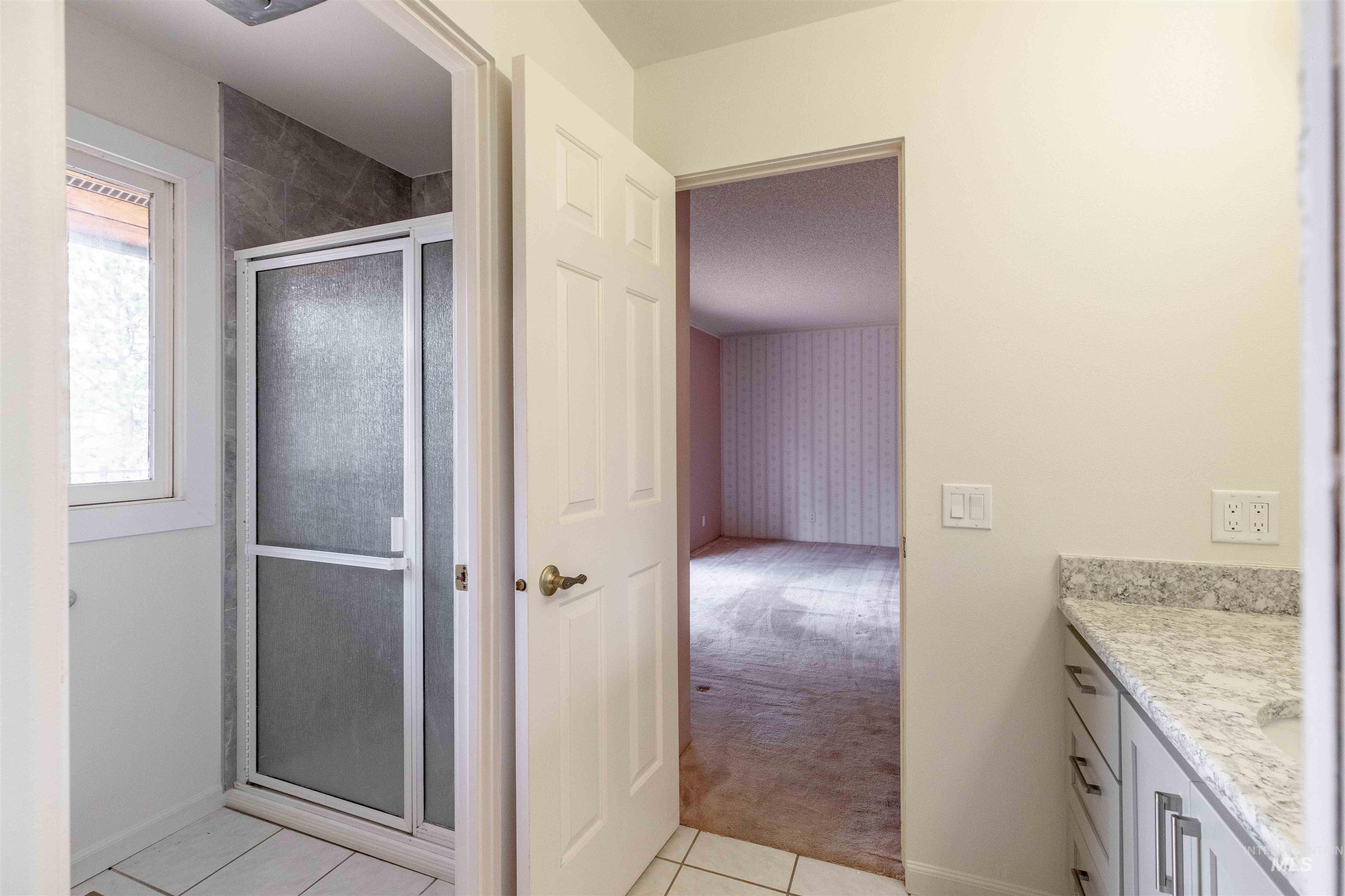 1050 Paradise Ridge Road Moscow, ID 83843 - Photo 23 of 49 Full bath featuring vanity, a stall shower, light colored carpet, and light tile patterned floors