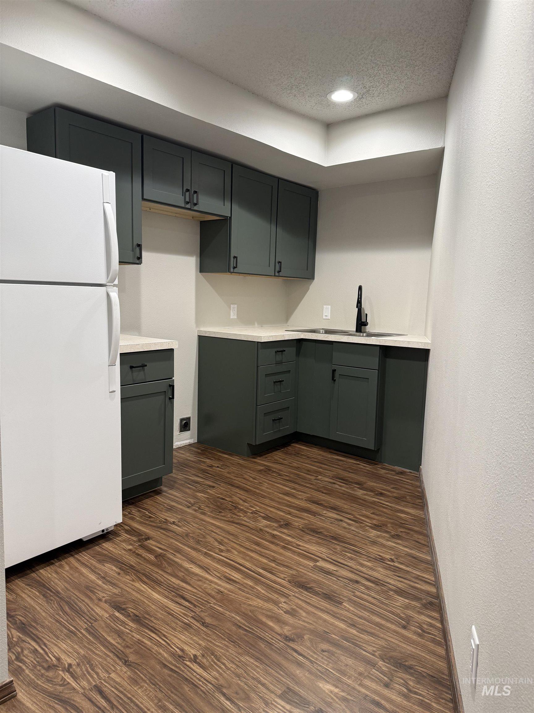 1050 Paradise Ridge Road Moscow, ID 83843 - Photo 24 of 49 Kitchen featuring freestanding refrigerator, light countertops, dark wood-style floors, recessed lighting, and a textured ceiling