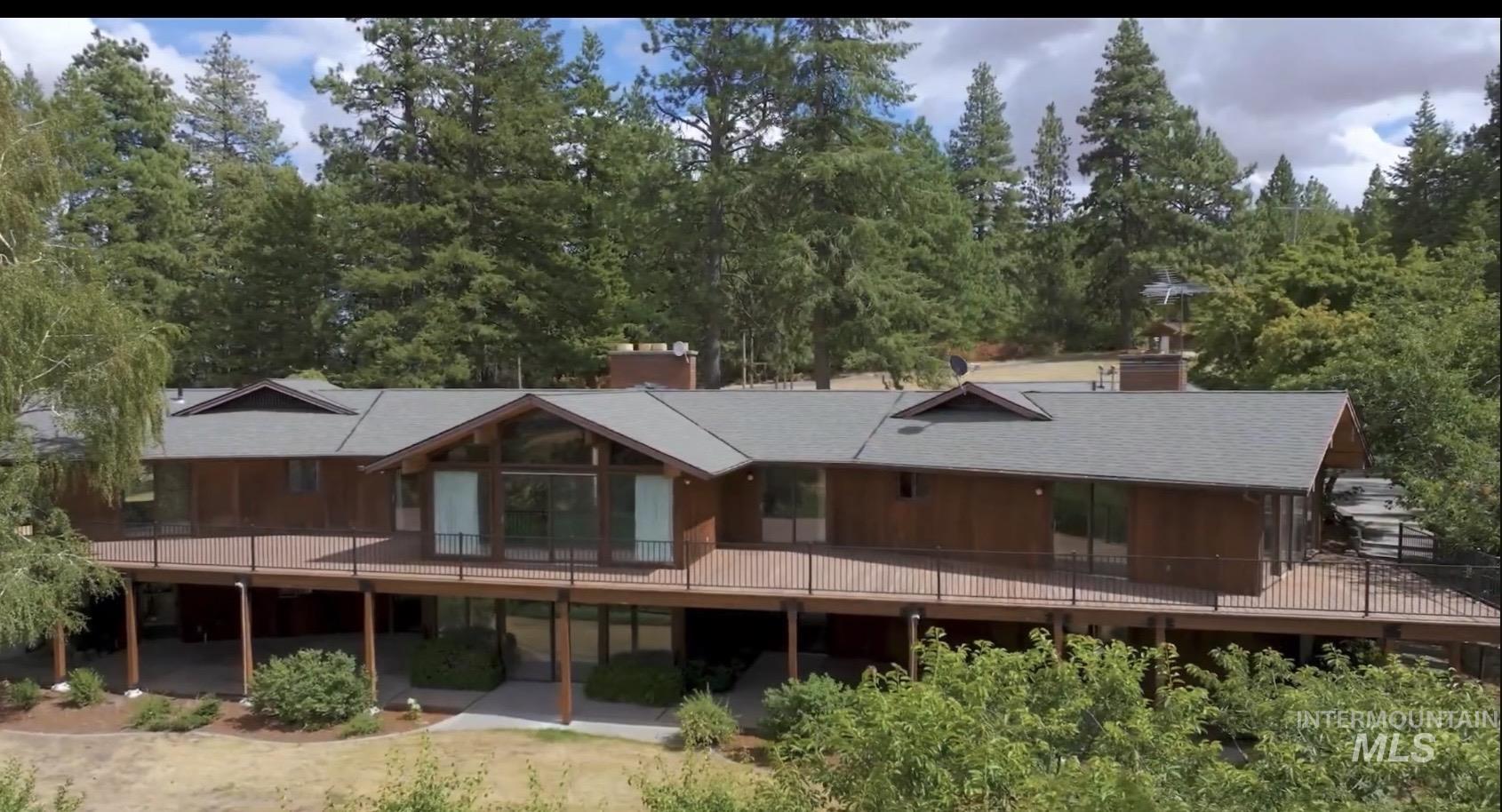 1050 Paradise Ridge Road Moscow, ID 83843 - Photo 48 of 49 Rear view of house with a chimney, view of scattered trees, and a balcony