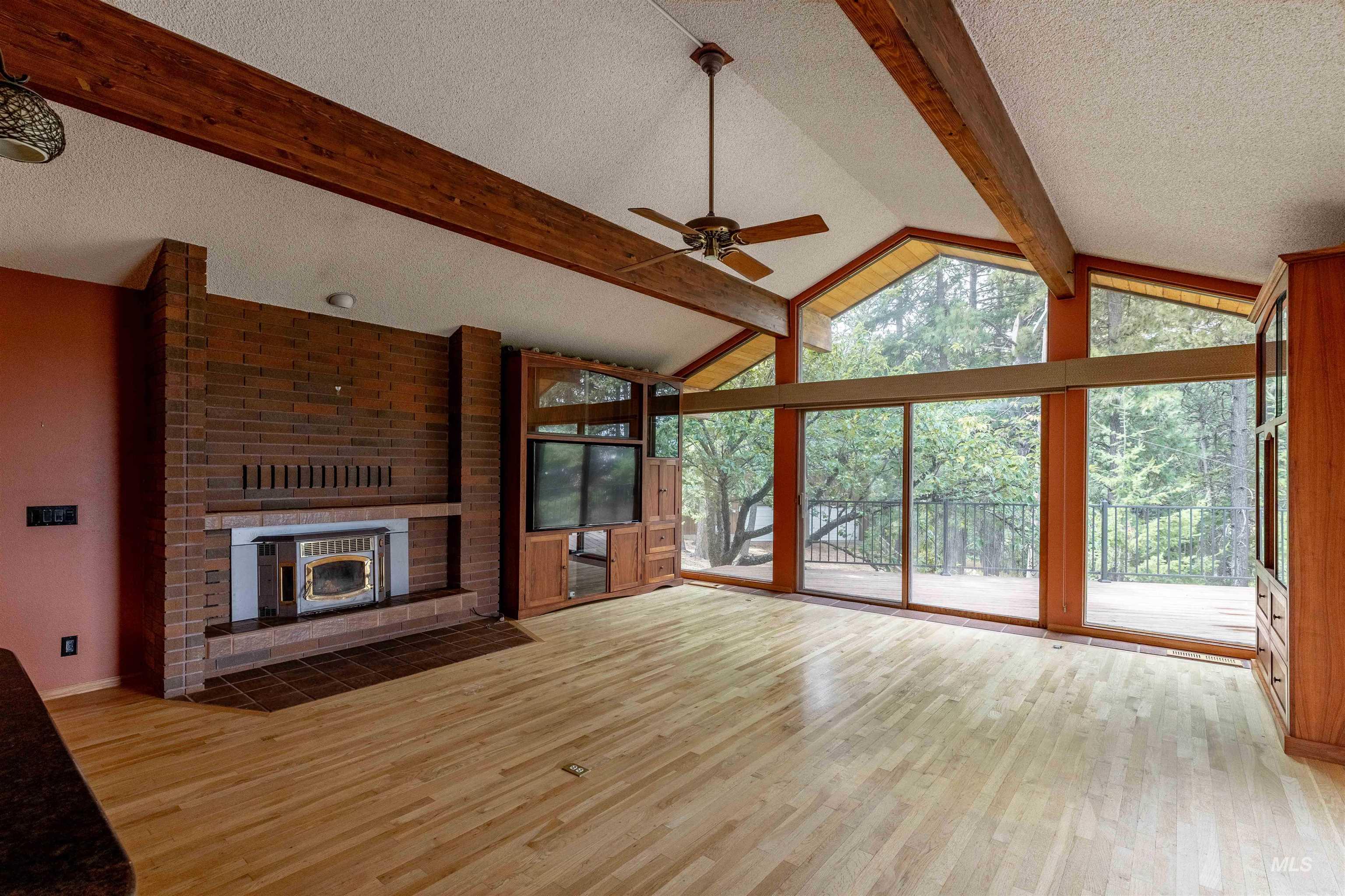 1050 Paradise Ridge Road Moscow, ID 83843 - Photo 7 of 49 Unfurnished living room with a ceiling fan, light wood finished floors, a textured ceiling, and a brick fireplace