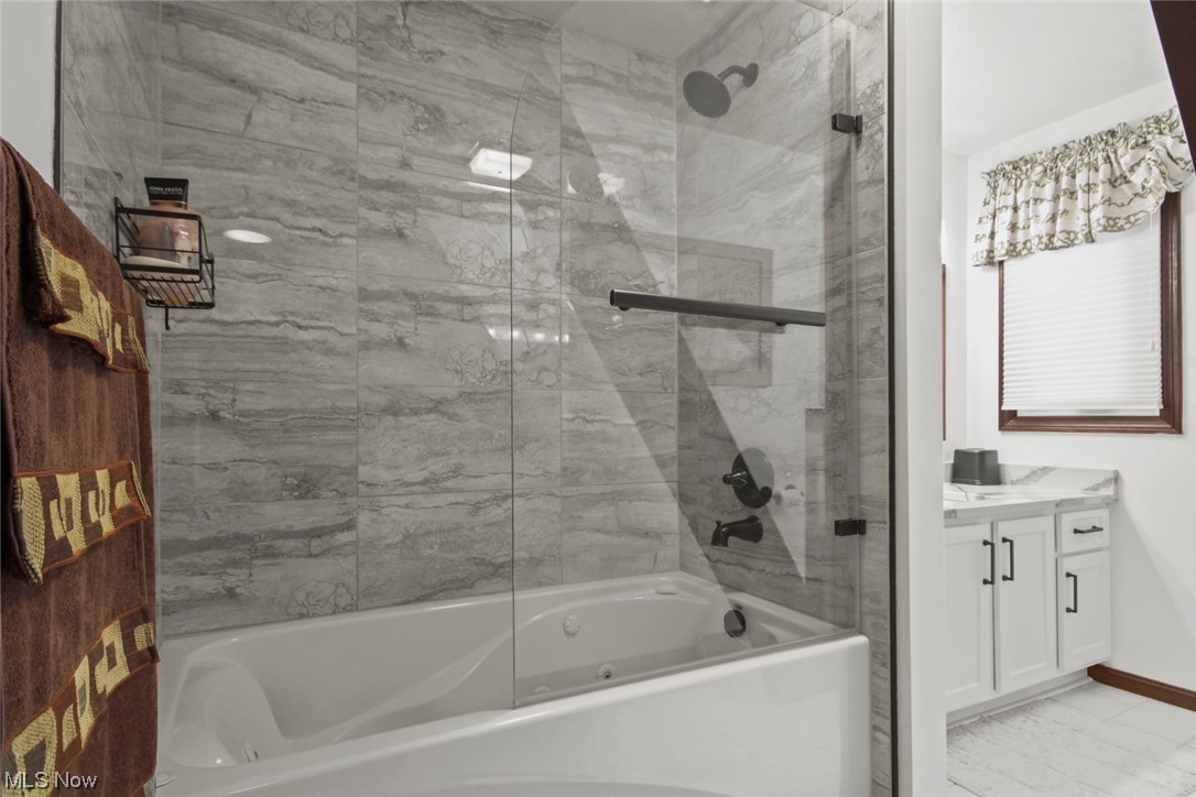 7550 South Raccoon Road Canfield, OH 44406 - Photo 11 of 32 Bathroom featuring tile floors, combined bath / shower with glass door, and vanity