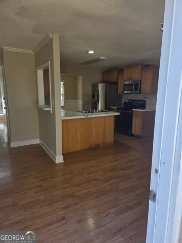 a view of kitchen with stainless steel appliances wooden floor sink and stove