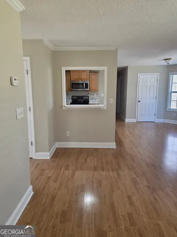 a view of empty room with wooden floor
