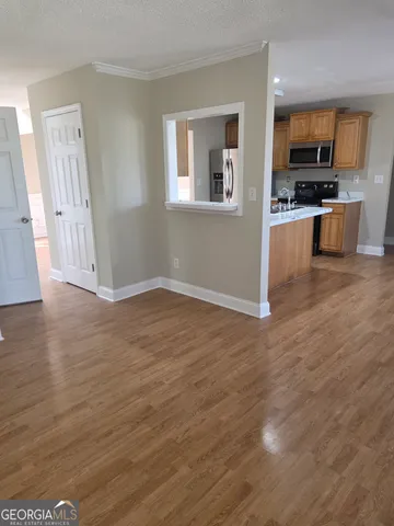 a view of kitchen with microwave a stove and wooden floor