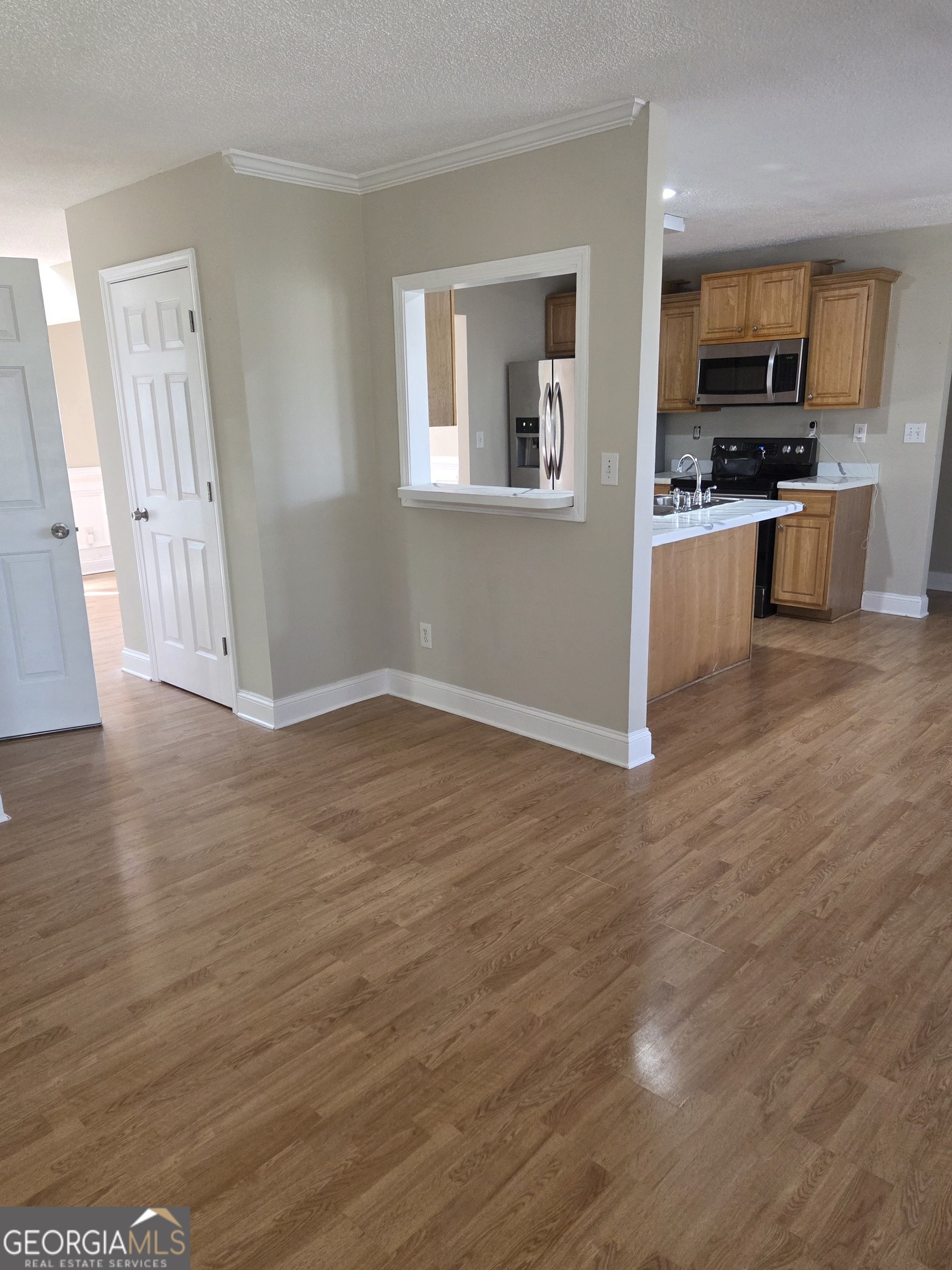 130 Stephanie Lane Covington, GA 30016 - Photo 4 of 18 a view of kitchen with microwave a stove and wooden floor