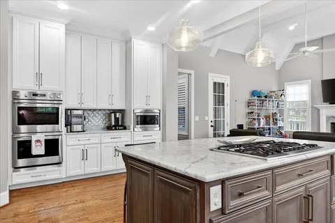 a kitchen with stainless steel appliances a stove a sink dishwasher and a refrigerator with wooden floor