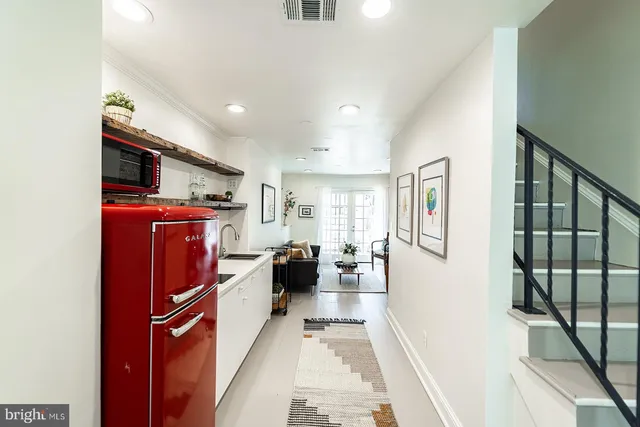 a kitchen with sink refrigerator and wooden floor