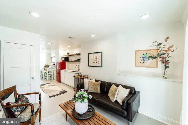 a living room with furniture kitchen and a table