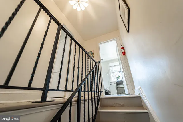 a view of staircase with railing and white walls