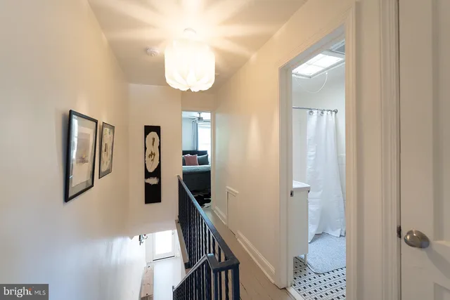 a view of a hallway with a livingroom and a chandelier fan