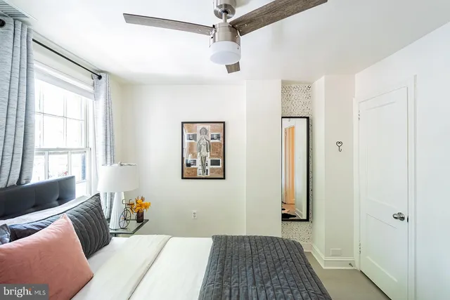 a bedroom with a bed and a couch with window