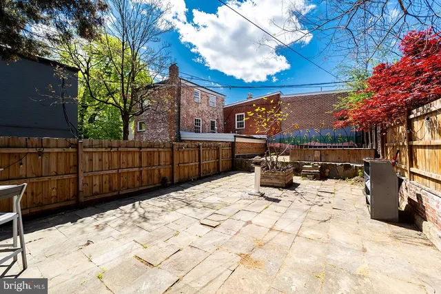 a view of roof deck with wooden fence and trees