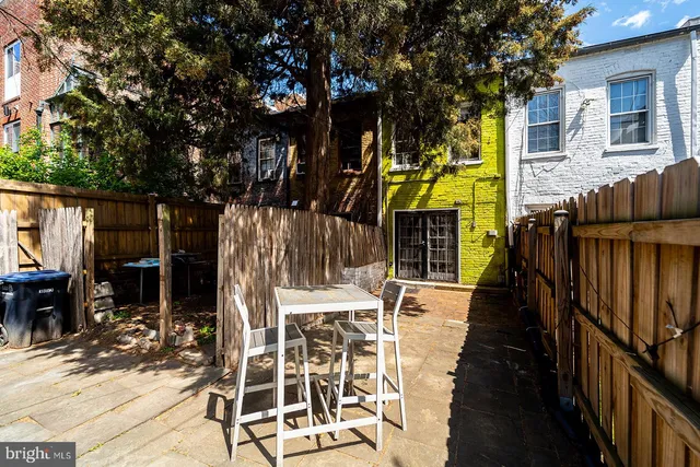 a view of a patio with table and chairs with wooden floor and fence