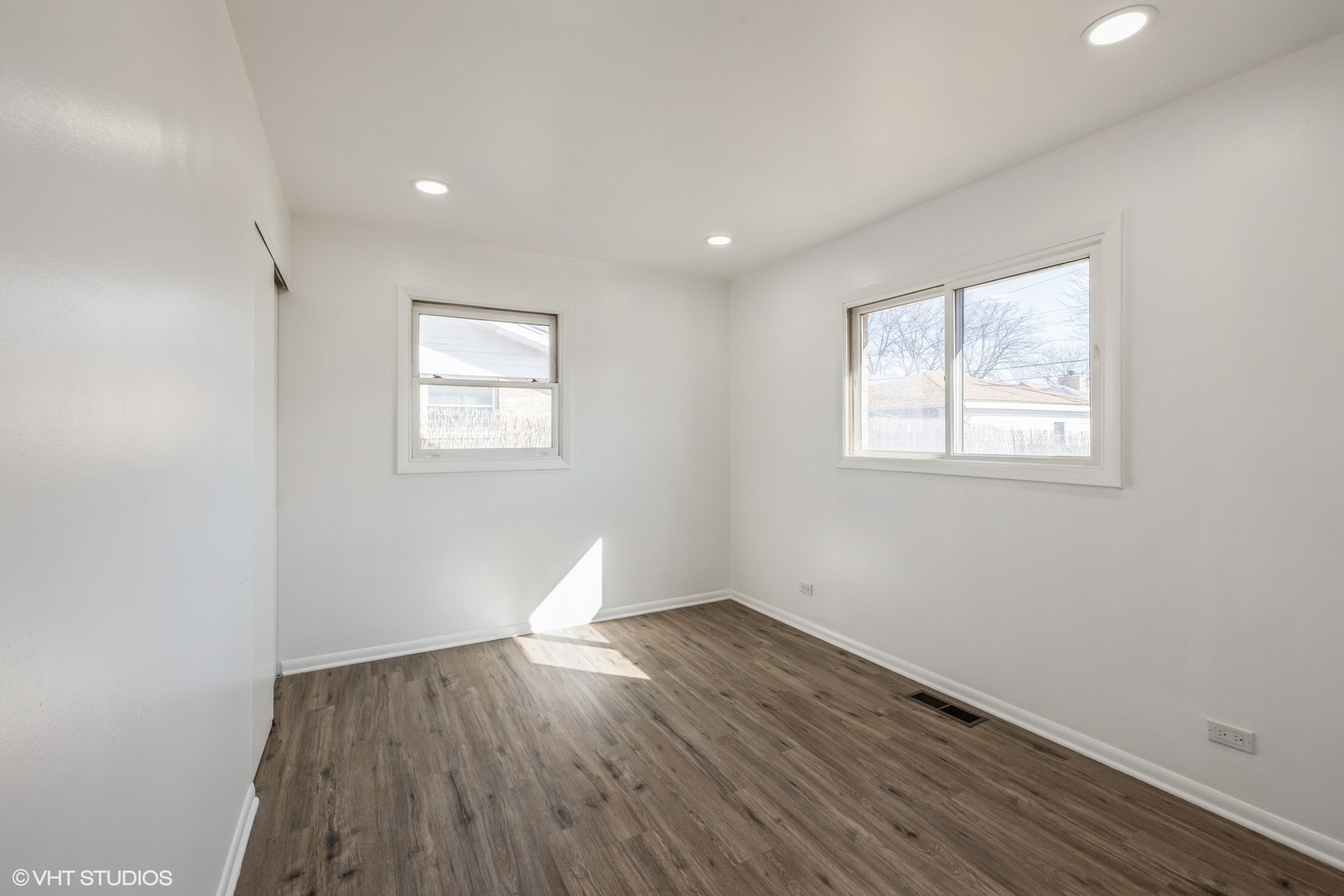 8713 Cranbrook Lane Bridgeview, IL 60455 - Photo 8 of 15 an empty room with wooden floor and windows