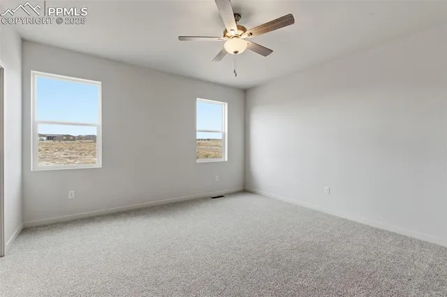 an empty room with a window and a fan