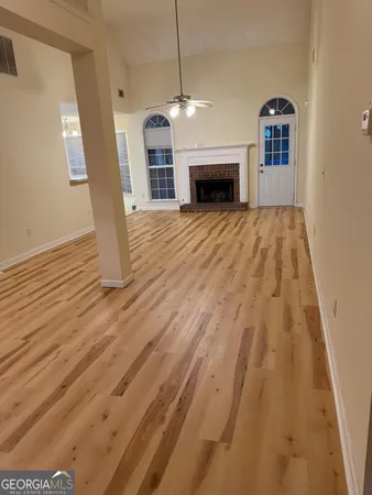 a view of empty room with wooden floor and fireplace
