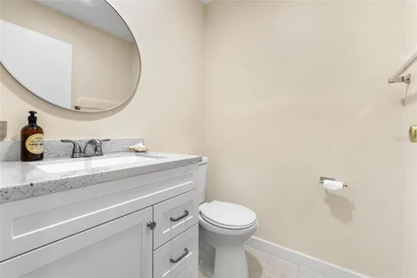a bathroom with a granite countertop toilet sink mirror and vanity