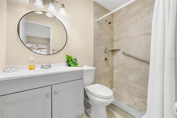 a bathroom with a sink a mirror a toilet and a shower