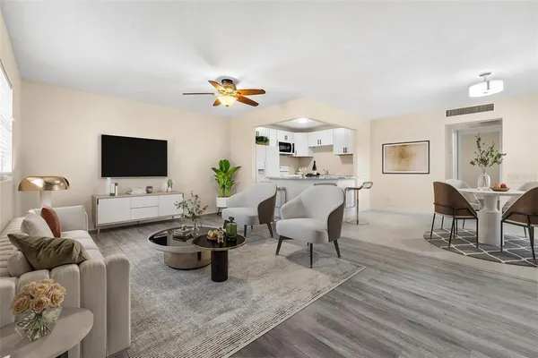 a living room with furniture a flat screen tv and a dining table with wooden floor