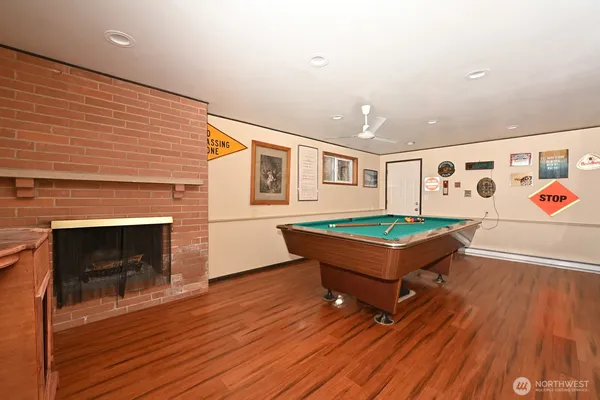 a room with wooden floors and pool table