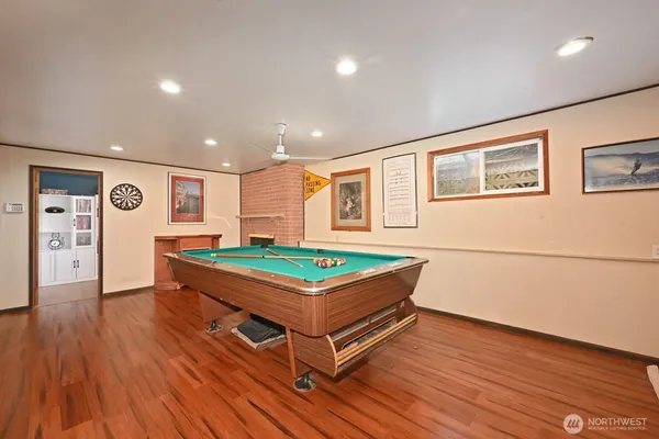 a room with wooden floors and pool table