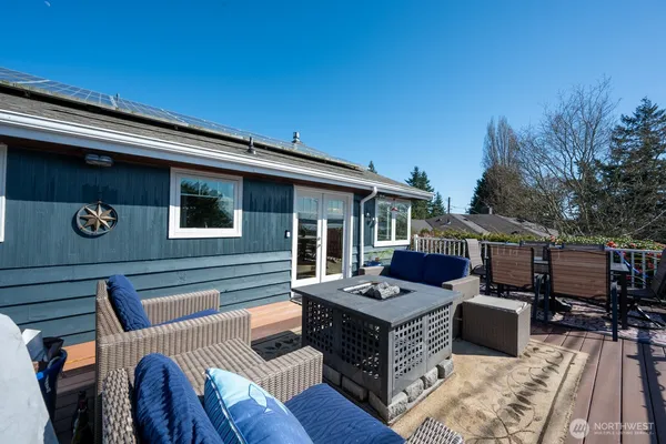 a view of a patio with couches table and chairs with wooden floor and fence