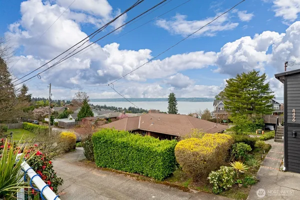 a front view of a house with a yard and lake view