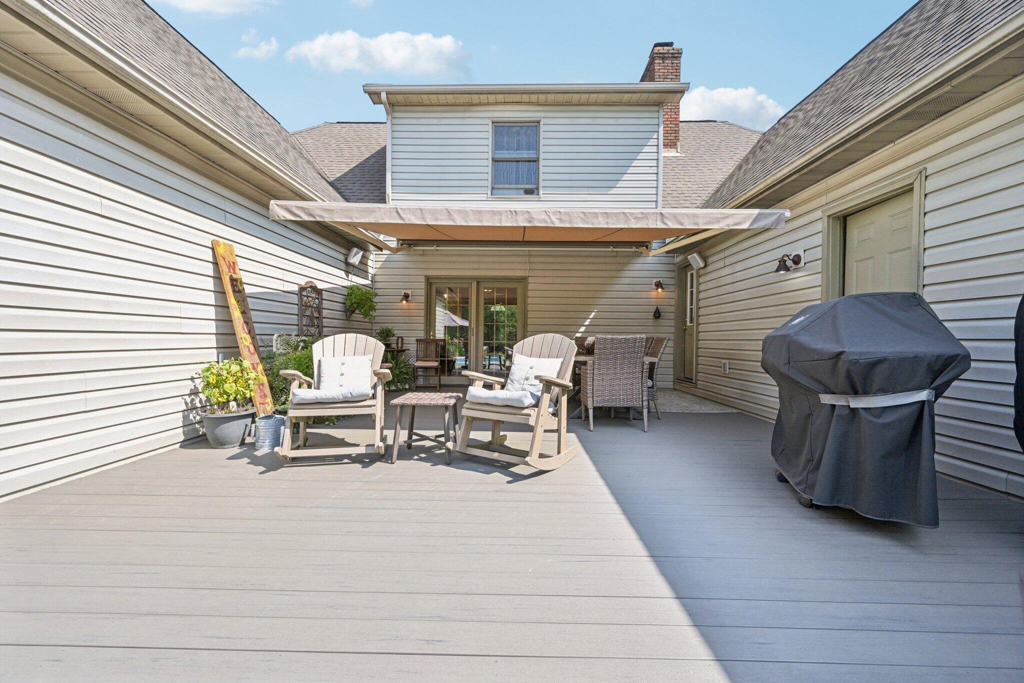 7700 Plumb Road Galena, OH 43021 - Photo 14 of 94 Covered outdoor space offers a shaded retreat with ample room for al fresco meals and lounging—ideal for all-season enjoyment.