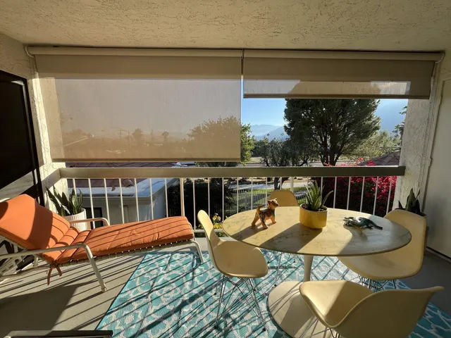 a view of a balcony dining area with furniture