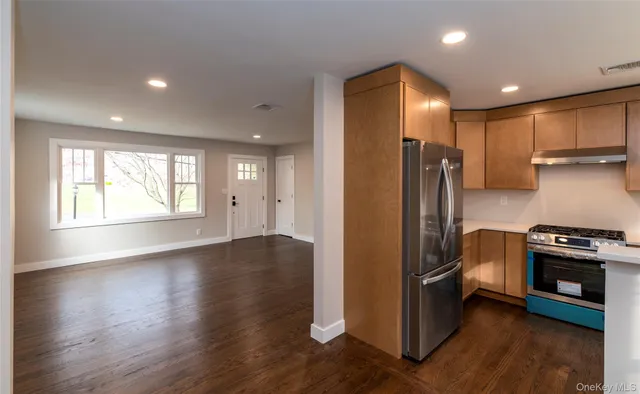 a view of a kitchen with a stove fridge and wooden floor