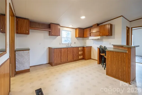 a large kitchen with stainless steel appliances granite countertop a stove a sink and a refrigerator