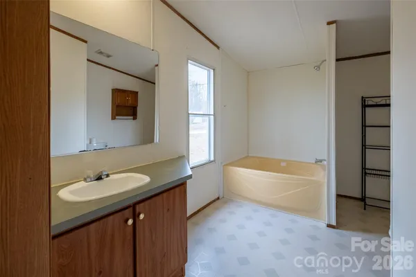 a bathroom with a tub sink and mirror