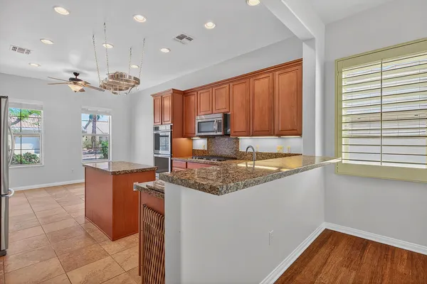 a kitchen with stainless steel appliances granite countertop a refrigerator and a sink